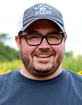 headshot of chef Sean Brock, standing in a field