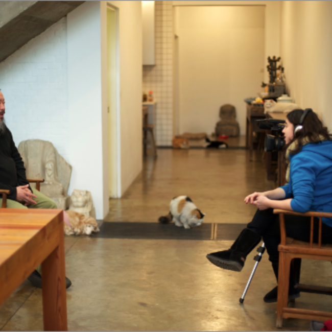 Wide shot of Ai Weiwei being interviewed by Alison Klayman at his studio