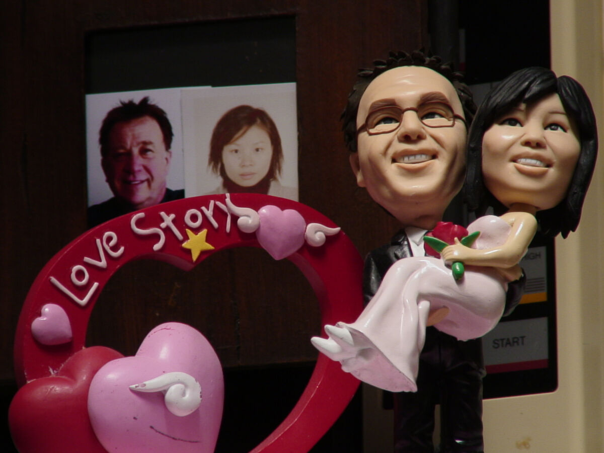 Figurines of wedding man and woman with "love story" written in heart beside them