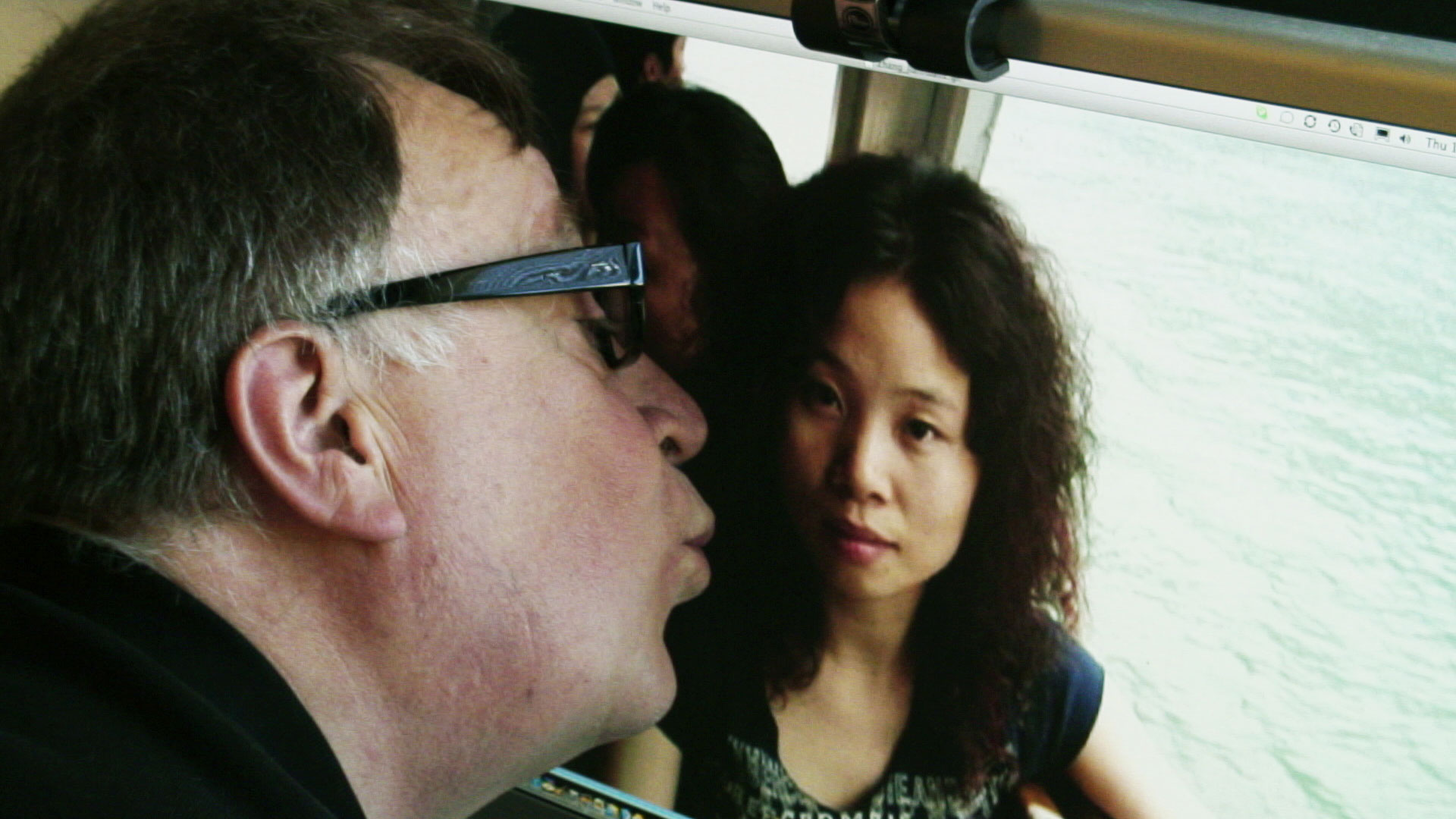 Steven of kissing photo of Asian woman on computer screen.