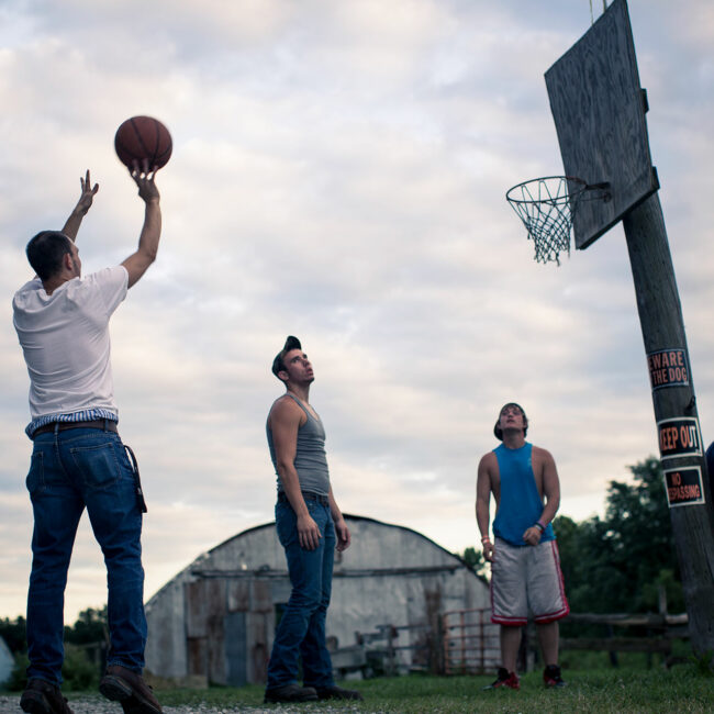 Kids of Medora shooting basketball outside in their street clothes
