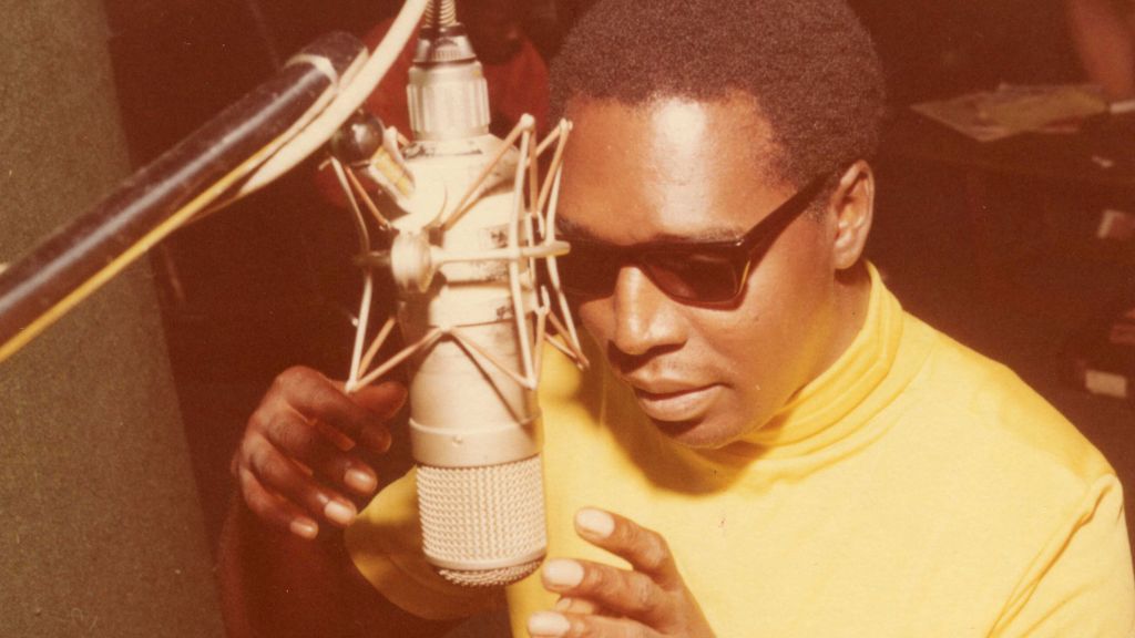 Clarence Carter sings into mic at Muscle Shoals studios.