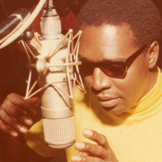 Clarence Carter sings into mic at Muscle Shoals studios.