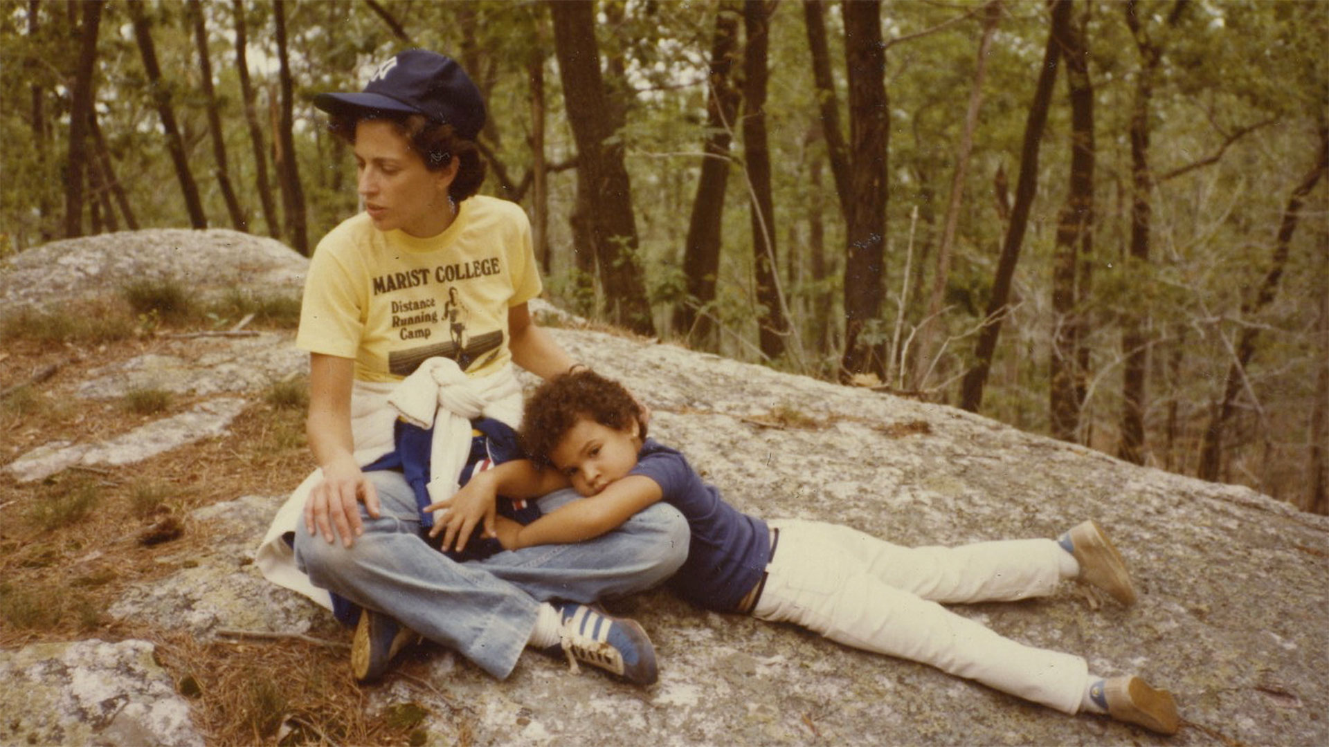 Young Lacey Schwartz lies on her mother's lap in the woods.