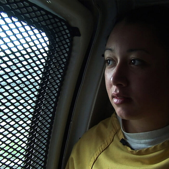 Cyntoia Brown gazes out a prison van window.