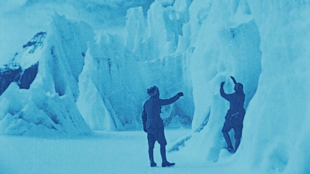 Still frame from The Epic of Everest (1924), men exploring an ice cave on the mountain.