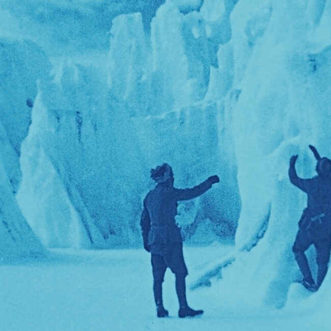 Still frame from The Epic of Everest (1924), men exploring an ice cave on the mountain.