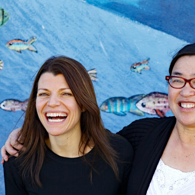 East of Salinas filmmakers Laura Pacheco and Jackie Mow (l-r), in front of a sea-themed mural.