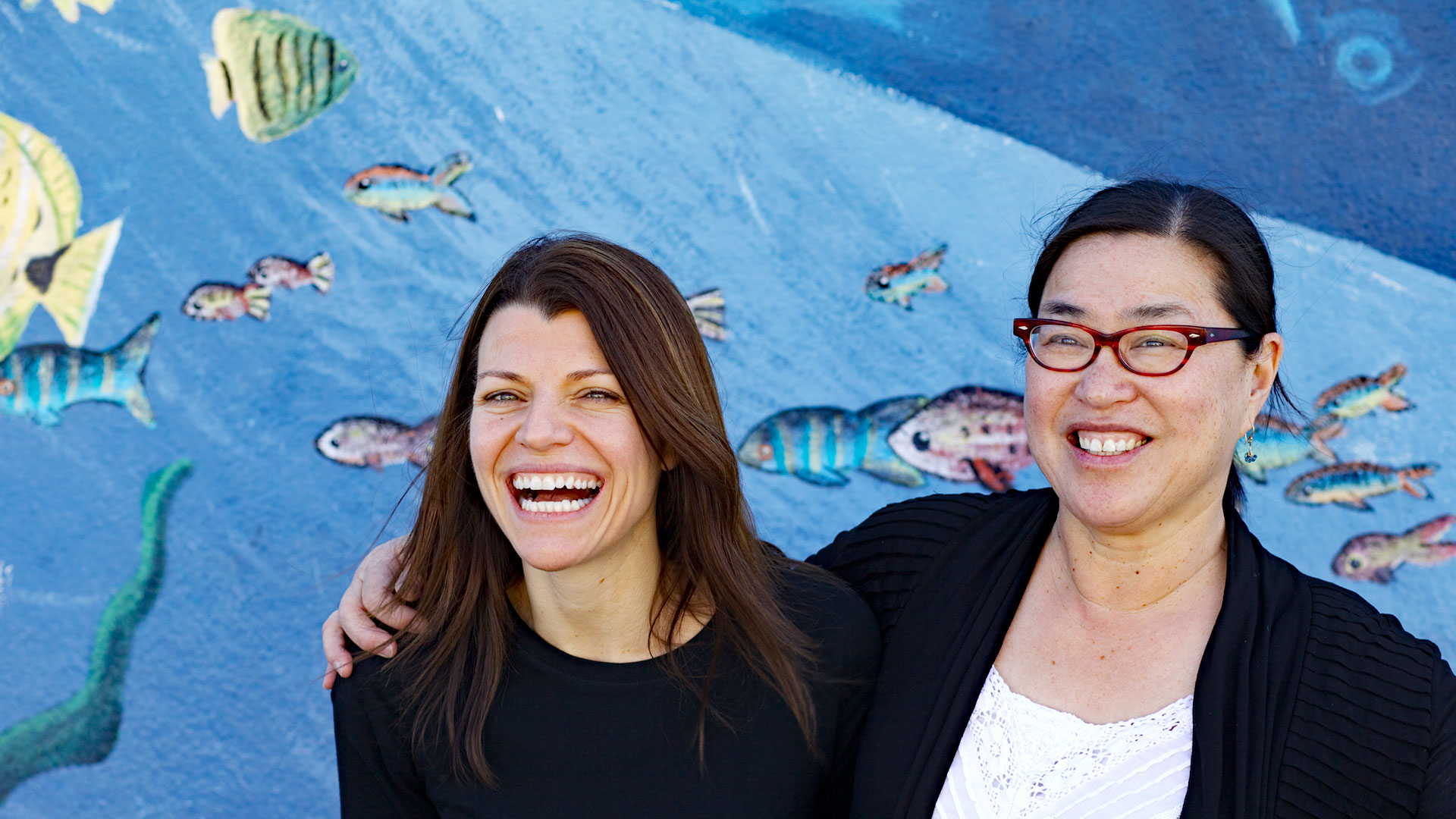 East of Salinas filmmakers Laura Pacheco and Jackie Mow (l-r), in front of a sea-themed mural.