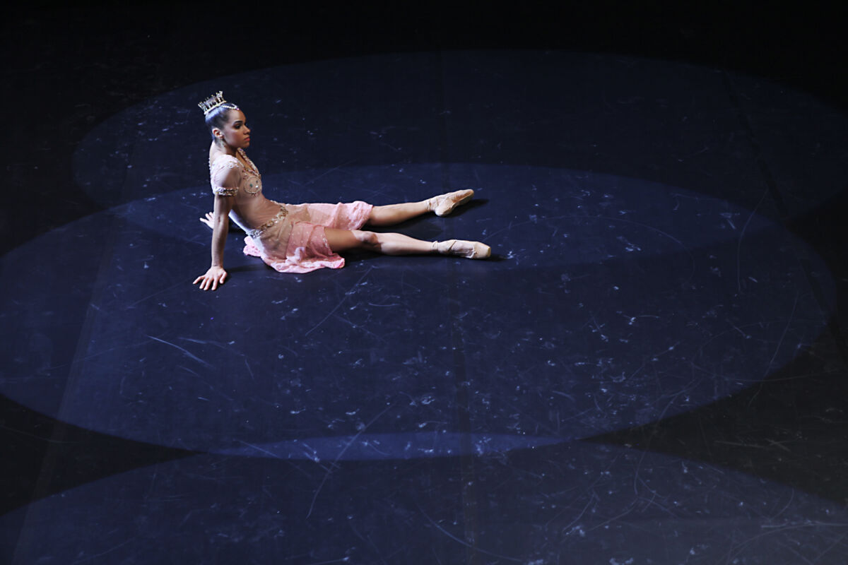 Misty Copeland sitting on stage in costume and shoes on