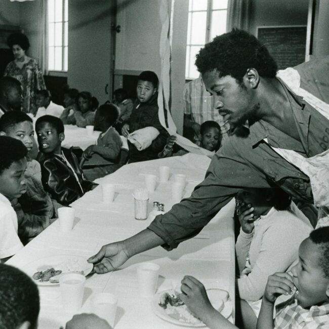 man serving many children at Black Panther breakfast program