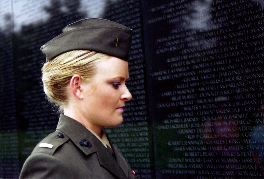 Elle in full uniform in The Invisible War stands at the Vietnam War Memorial