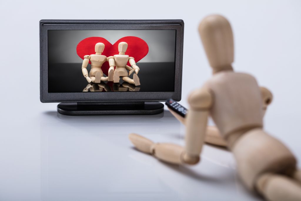 Wooden Figure Lying On Floor Watching Television, By Andrey_Popov, via Shutterstock