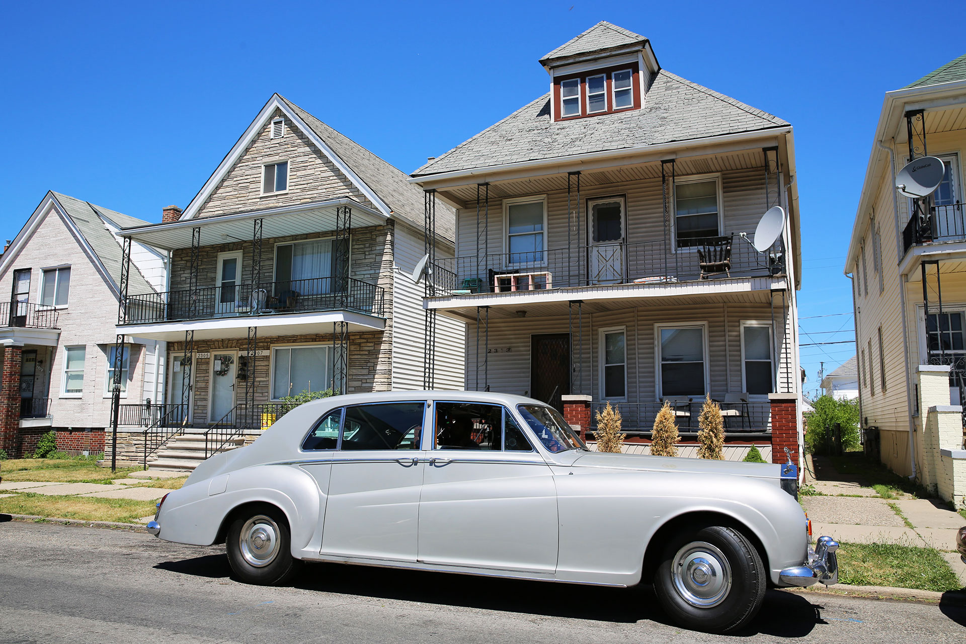 Elvis Presley's Rolls-Royce parks in front of a row house, in The King