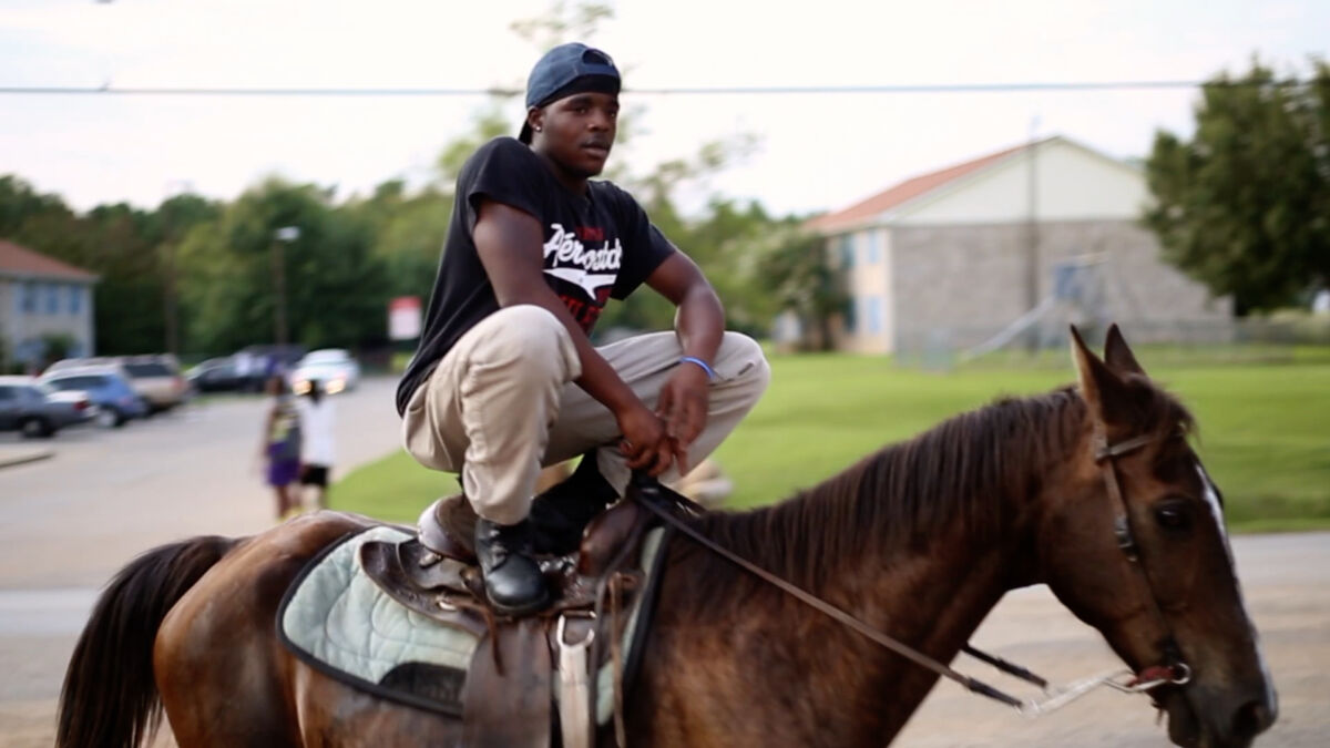 Young man standing on a horse