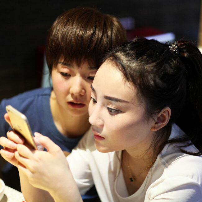 Shen Man and Dabao looking at live streaming on a phone, in People's Republic of Desire