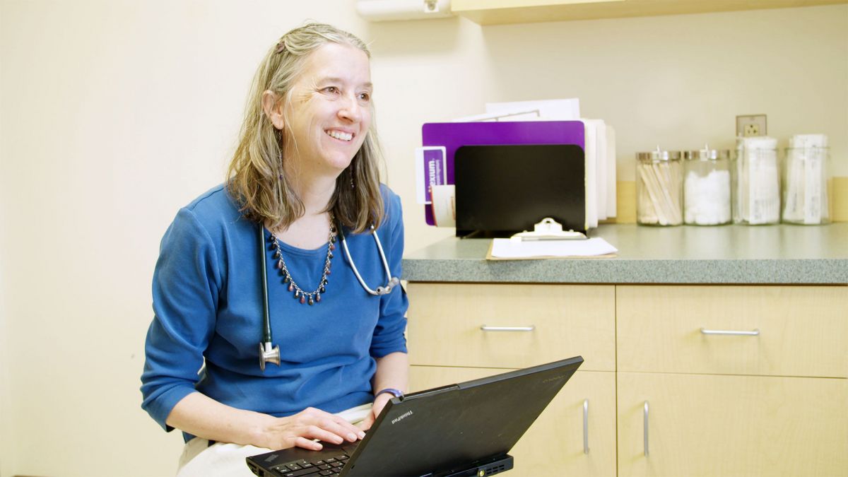 Dr Leslie Hayes, smiling at work in her office, in The Providers