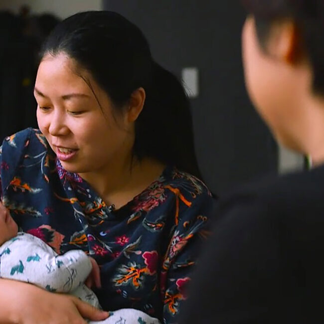 Nanfu wang holds her baby while interviewing her mother