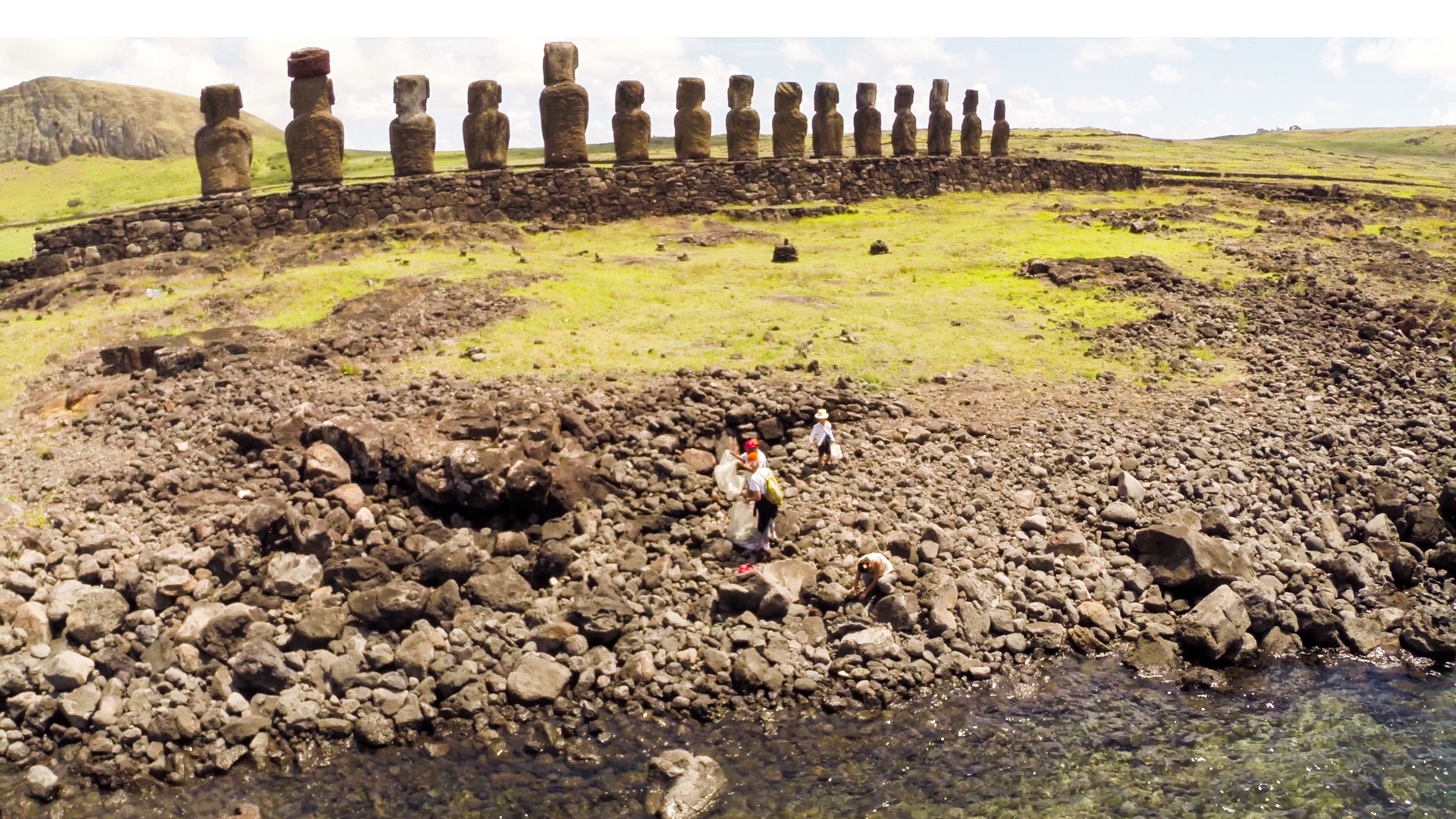 Beach cleanup under way on Rapa Nui while the famous statues loom in background