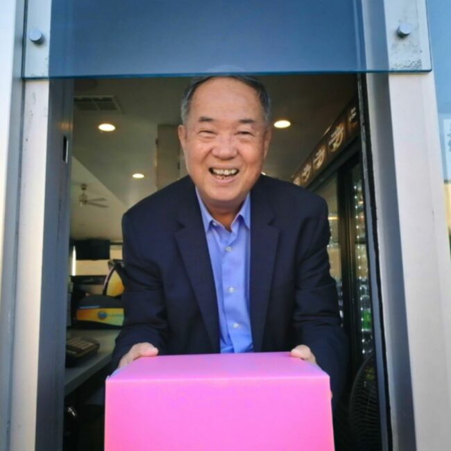 Ted Ngoy holds his famous pink pastry box, in The Donut King