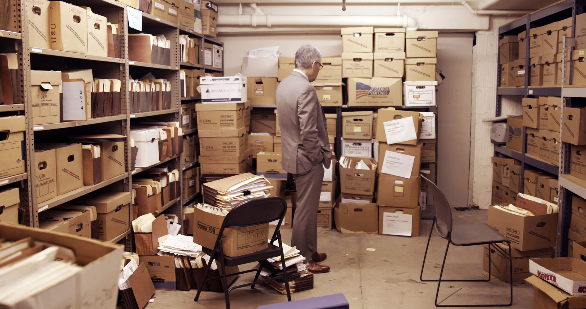 Larry Krasner looks over a ton of file boxes from way back, in Philly D.A.