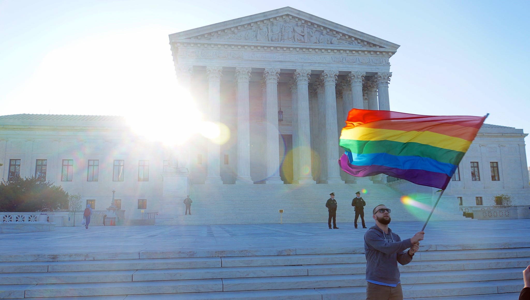 steps of Supreme Court, Man carrying Pride flag.