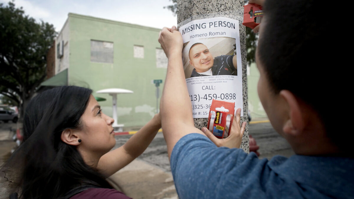 The Romans family putting up missing person poster in Brooks County, for their missing brother