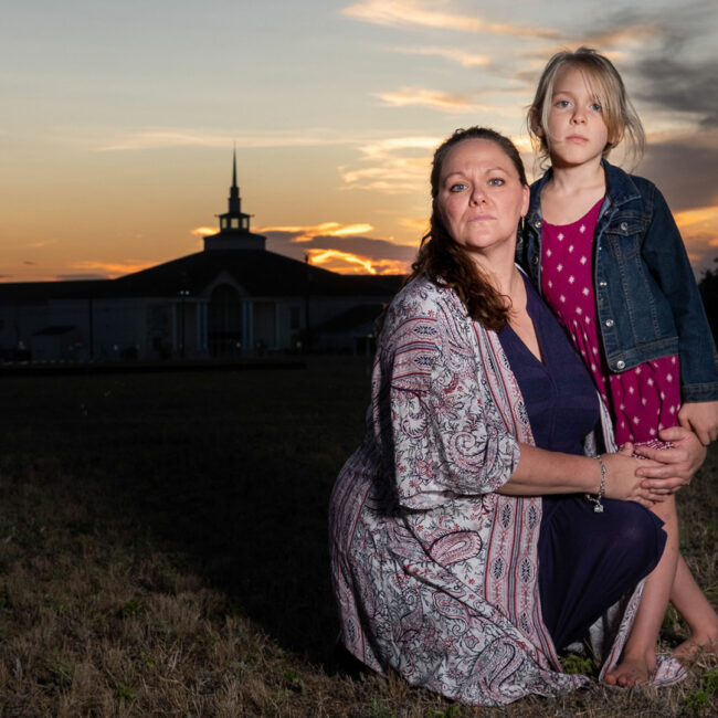 Kimberley and daughter Kai stand in front of a church at sunset