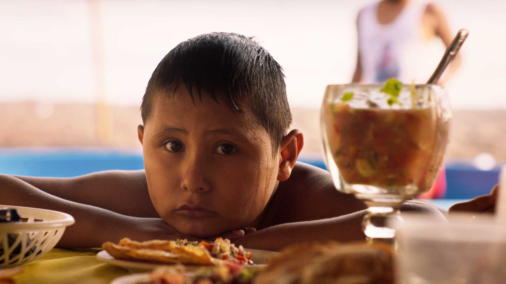 Young Sansón as played by young cousin Tonito, looking sadly across a table in Mexico
