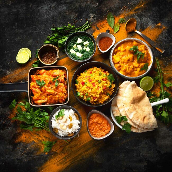 Assorted indian food on black background.. Indian cuisine. Shutterstock photo, By Tatjana Baibakova