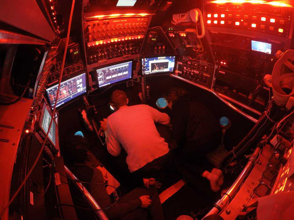 Interior of Alvin’s titanium sphere during a dive on the East Pacific Rise in December 2018 showing the pilot in the middle and two scientists. (c) Woods Hole Oceanographic Institution, National Deep Submergence Facility and National Science Foundation Sealab-scientist-2.jpg