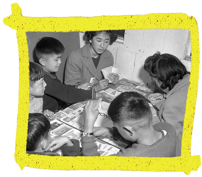 Closeup of six children playing Monopoly in the Puyallup incarceration camp.