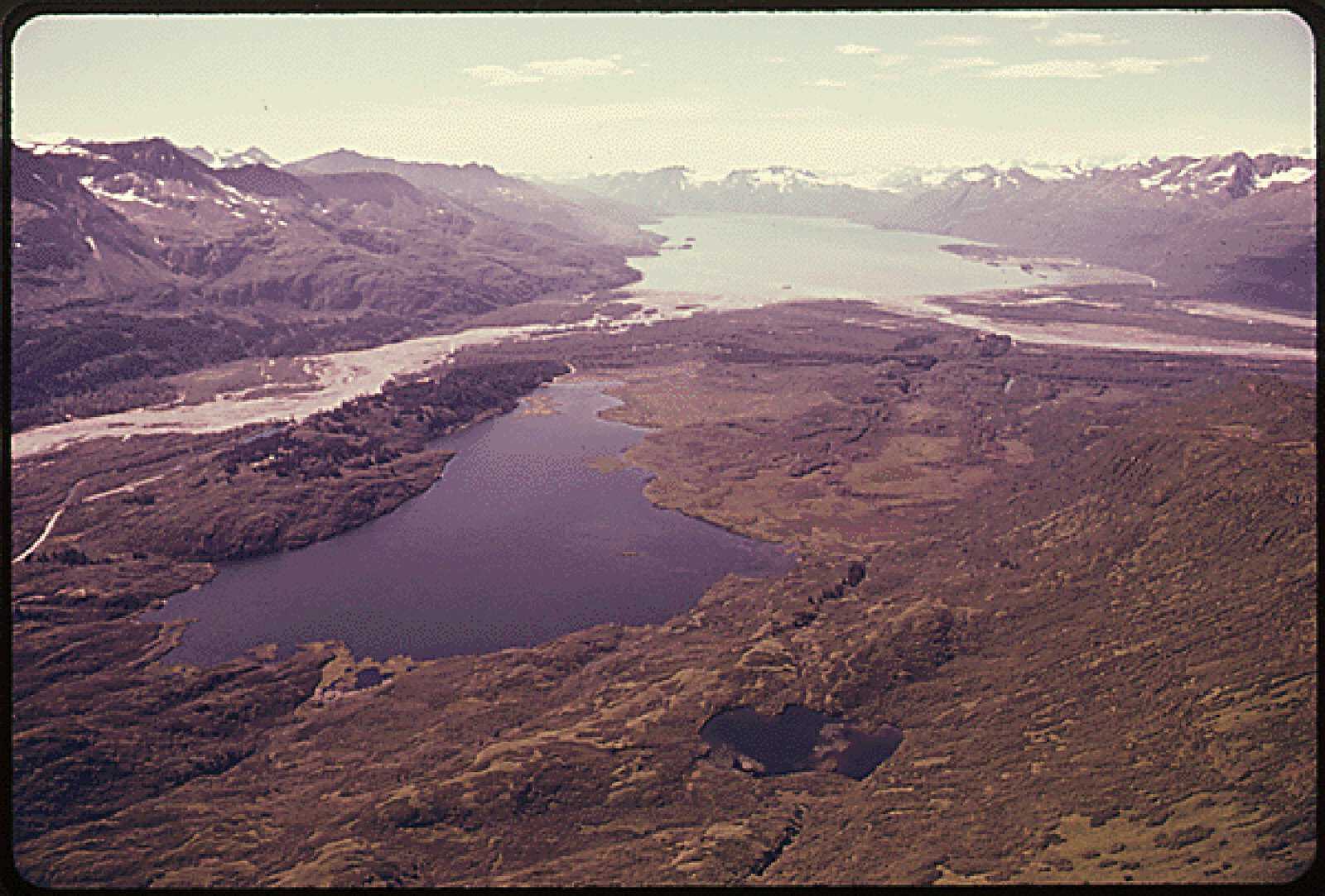 View west to port Valdez, the glacial fiord that will be the Trans-Alaska pipeline terminus, with Robe lake in the foreground the Lowe river dumps its burden of silty rock flour into port Valdez, an arm of the Pacific Ocean at center left. NA. Pipeline-timeline-NA.jpg
