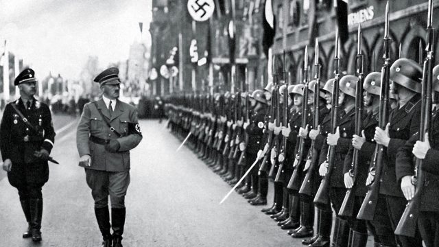 Adolf Hitler and Heinrich Himmler review a parade of Hitler s personal guard