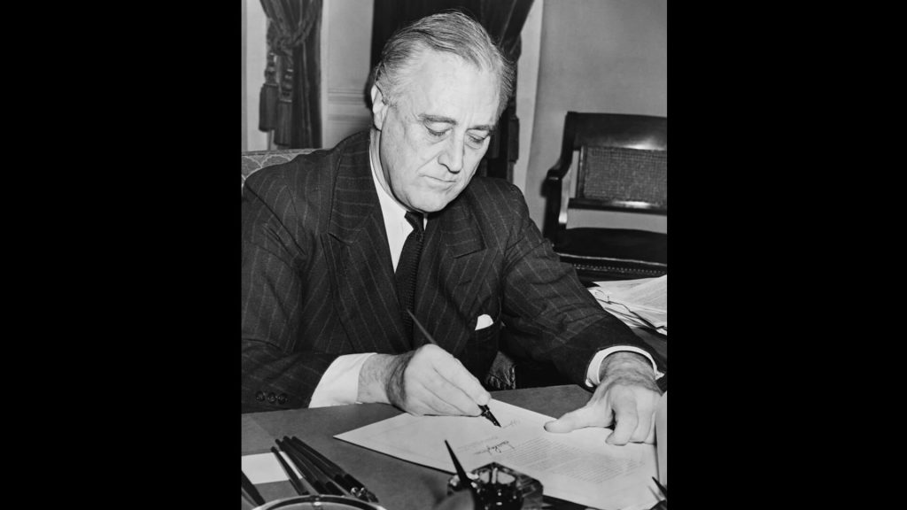 President Franklin D. Roosevelt signing the lend-lease bill on March 11, 1941.
