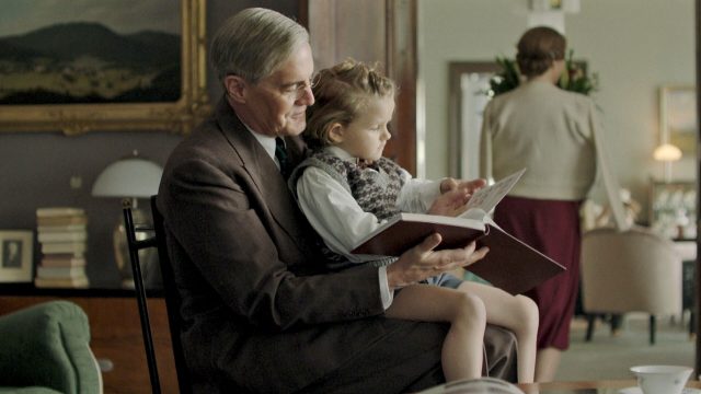 Actor Kyle MacLachlan as President Franklin Roosevelt with a child in his lap in Atlantic Crossing.