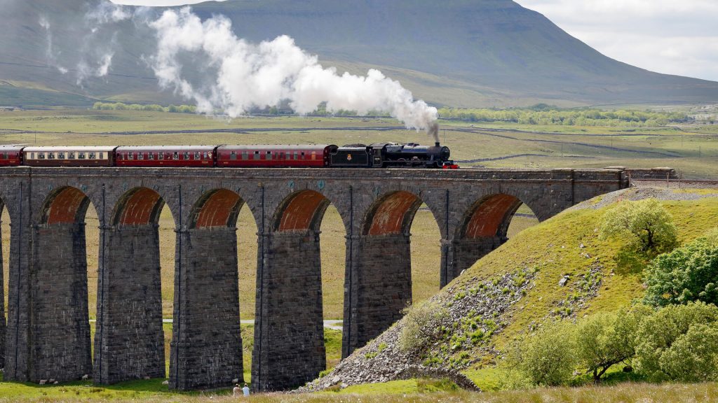 Steam train crossing Ribblehead Viaduct in Yorkshire Dales, England