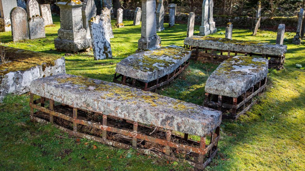 Photo of four “mortsafes” designed to protect graves from disturbance by body snatchers.