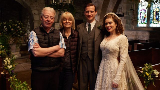 Author James Herriot's grown children Jim Wight and Rosie Page on the set of MASTERPIECE on PBS's All Creatures Great & Small with actors Nicholas Ralph and Rachel Shenton.