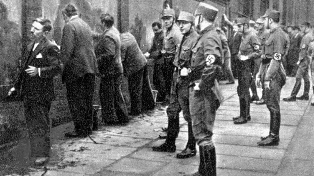 Black and white photograph from 1933 showing the arrest of communists and socialists by members of the Nazi storm battalion (SA).