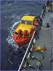 Miller prepares to grab ladder, with deckhands at the ready.