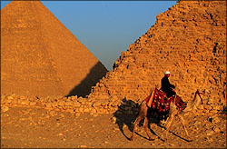 Pyramids with man on camel in foreground