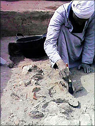 Man brushing carefully at partially-buried shards