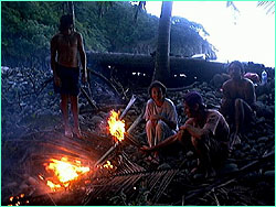 Soaking from a day in the rain, we enjoy a fire while awaiting our ride home.