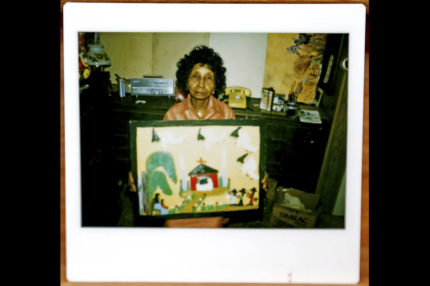 A snapshot of Hunter posing with one of her paintings. The question has become whether such photos serve in every case to establish the authenticity of her work.