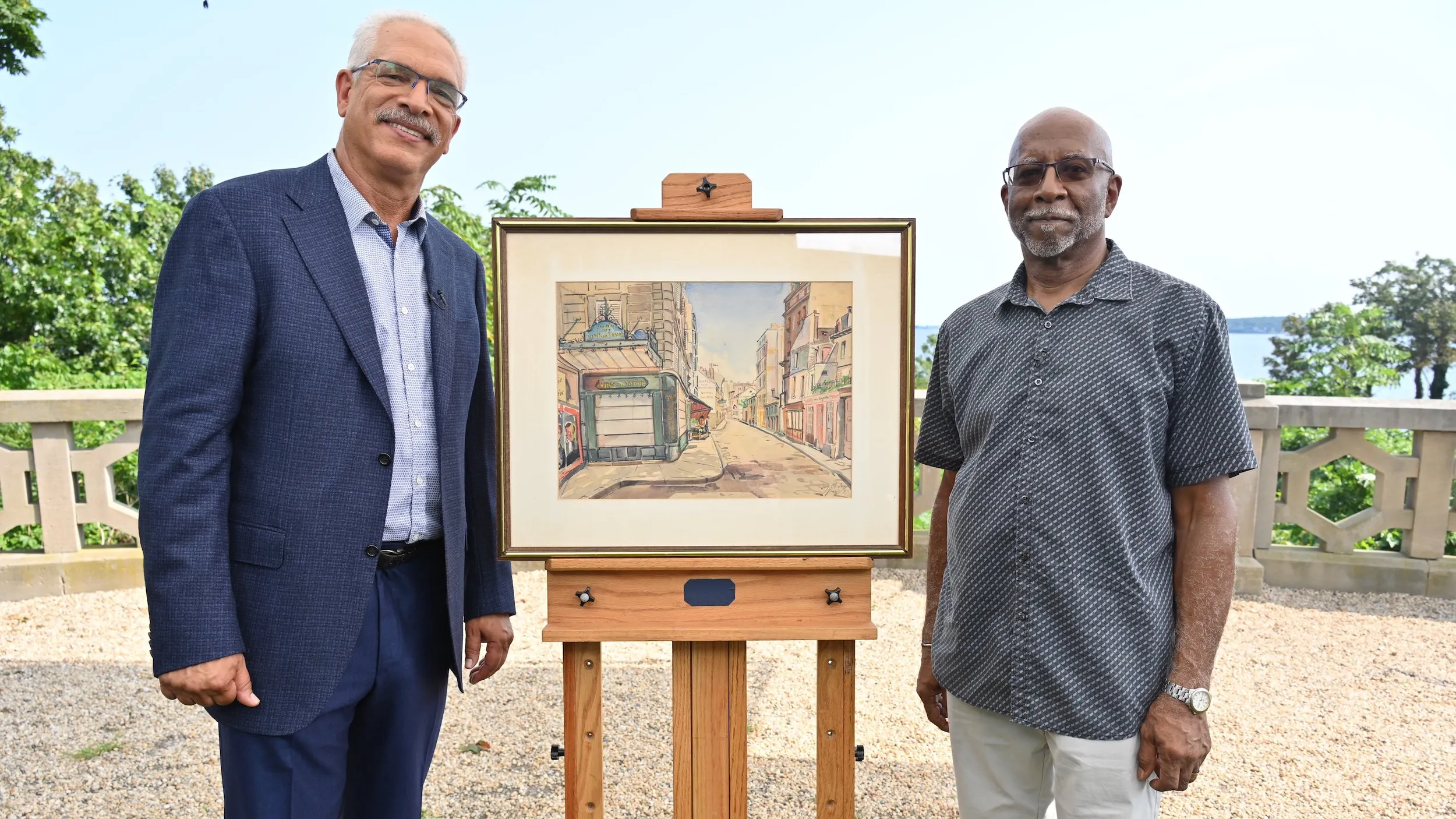 Appraiser Eric Hanks with a watercolor by Lois M. Jones, with the painting's owner